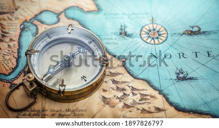 Magnetic old compass on world map. Travel, geography, navigation, tourism and exploration concept background. Treasure Island on the Pirate Map.