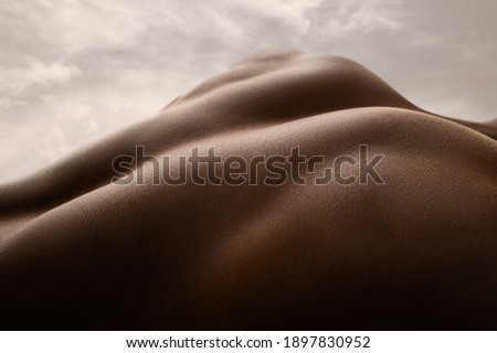 Shining. Detailed texture of human skin. Close up of young african-american male body surface like landscape with the sky on background. Skincare, bodycare, healthcare, inspiration, fantasy artwork. Royalty-Free Stock Photo #1897830952
