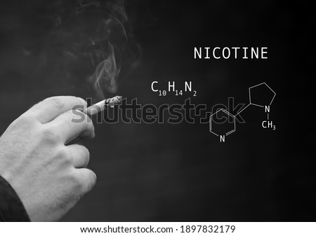 Structural molecular model of Nicotine on soft blurred background of a man's hand holding a cigarette with beautiful smoke.