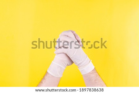Handshake of doctors in white medical gloves on a yellow background. The medicine. Successful operation. Place for an inscription. Handshake. The close plan. Advertising. Covid 19.