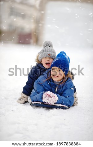 happy brother and sister playing  on the snow