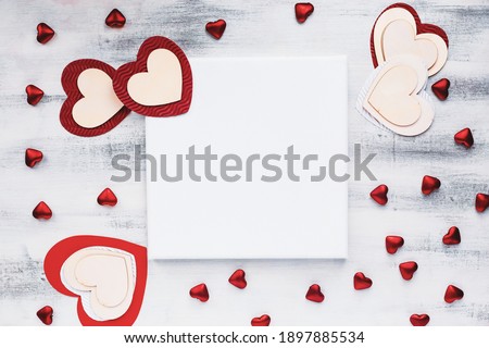 Valentine's Day card blank canvas with a variety of hearts over a wooden background. Copy space for text. Image shot from top view.