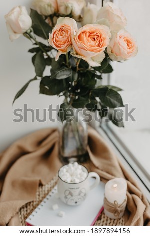 Morning cup of coffee, white notebook, roses in a vase. Beautiful breakfast. Flat lay style.