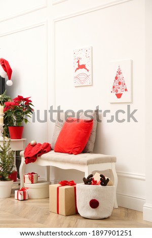 Christmas themed pictures in bright room with festive decorations. Interior design