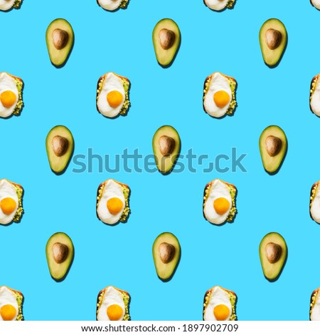 Seamless pattern of sandwich with scrambled eggs and avocado halves on a green background