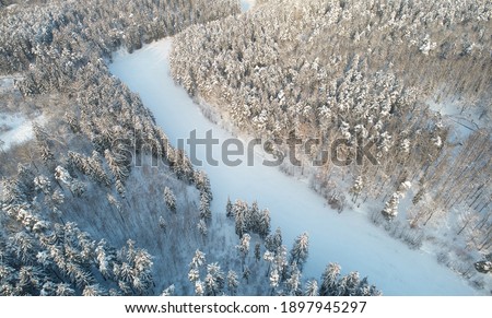 Frozen river in winter forest background aerial above drone view