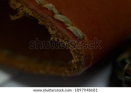 Dark picture of macro shot of leather case with leather fringes