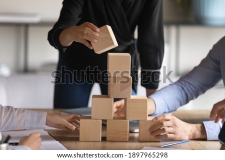 Close up employees team playing educational game with wooden cubes, involved in team building at corporate meeting, teamwork and collaboration concept, business activity, workshop, staff training Royalty-Free Stock Photo #1897965298