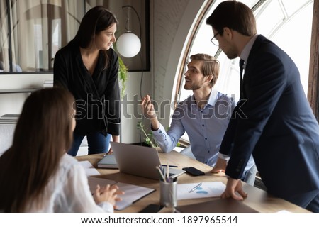 Close up motivated diverse employees discussing project strategy at meeting, sitting at table in modern boardroom, colleagues listening to mentor team leader, staff training, briefing concept Royalty-Free Stock Photo #1897965544