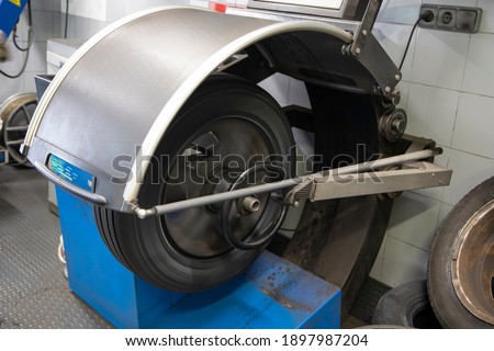 Machine balancing a wheel with a new tire. Picture of a workshop during a wheel change of a vehicle. Concept of a trade.