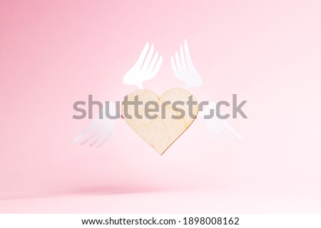 flying heart symbol over pink background. love and romance concept. valentine day greeting card conceptual.