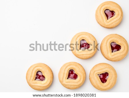 Cookies. Cookie Hearts shape Red jam or strawberry jelly inside biscuit cookie. Homemade baking. Sweet bakery. Top view on white background with copy space.