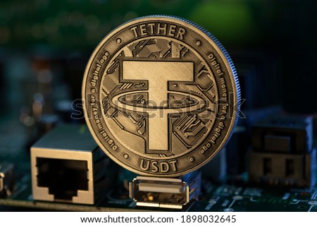 Tether USDT cryptocurrency physical coin placed on microscheme in the dark background. Selective focus. Royalty-Free Stock Photo #1898032645