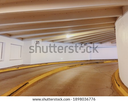 Circular ramp for cars between floors of a multi-storey car parking. Circular ramp entrance in multi-storey car parking