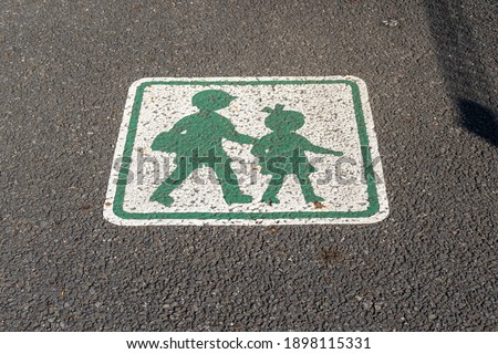Road sign on a pavement, calling for an attention for children.