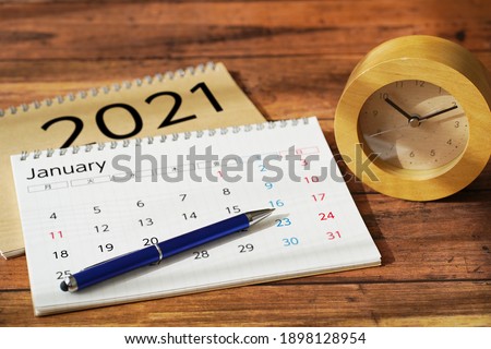 Calendar and schedule on wooden desk.The letters in the calendar mean the days of the week in Japanese.