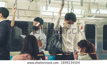 Crowd of people wearing face mask on a crowded public subway train travel . Coronavirus disease or COVID 19 pandemic outbreak and urban lifestyle problem in rush hour concept . Royalty-Free Stock Photo #1898134504