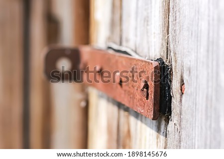 Old wooden barn door with steel hinges. Selective focus