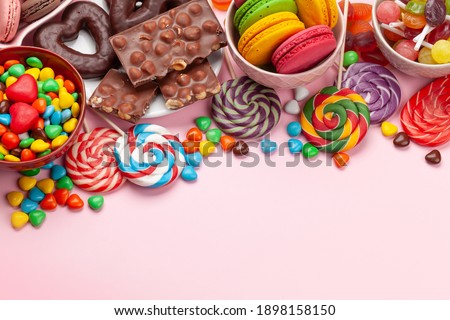 Various sweets assortment. Candy, bonbon and macaroons on pink background. Top view with copy space Royalty-Free Stock Photo #1898158150