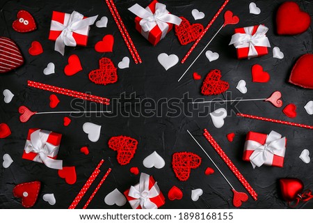 Valentine's day composition with hearts, gifts and copy space on black background. Top view, flat lay.