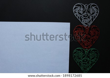 mock up three hearts silver red green on a black background with a place for mock up Valentine's Day.