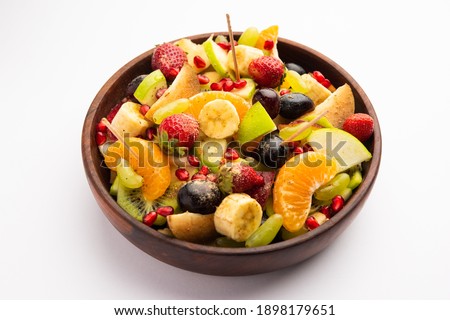 Fruit Chaat is a tangy Indian dish made by combining chilled juicy fruits like apples, bananas, oranges, grapes with salt and mild spices Royalty-Free Stock Photo #1898179651