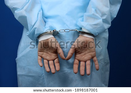 Doctor handcuffed, hands close-up, concept of medical corruption, bribery, crime