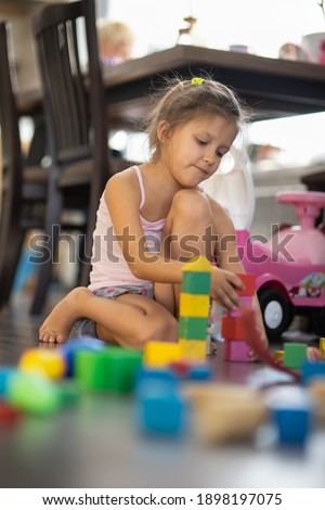 Girl six years old playing on the floor in the room