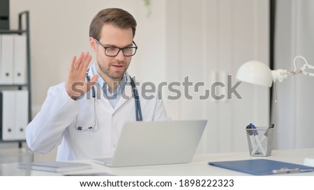 Male Doctor with Laptop having Headache in Clinic