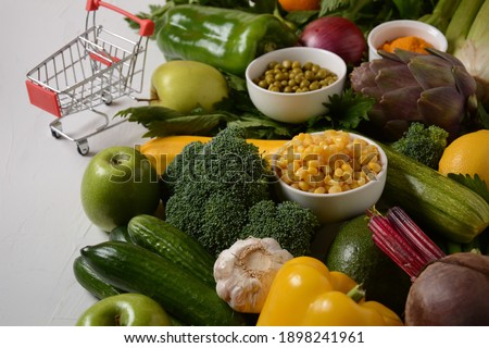 Shopping trolley cart and different fresh fruits and vegetables for layout. Assortment of fresh fruits and vegetables. Healthy food background. Shopping food in supermarket