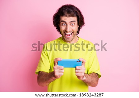 Photo of funny brunet hair man hand wear yellow t-shirt playing football modern device isolated pink color background