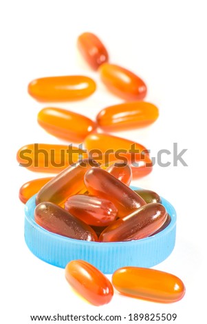 Transparent gold fish oil pills closeup isolated on white background