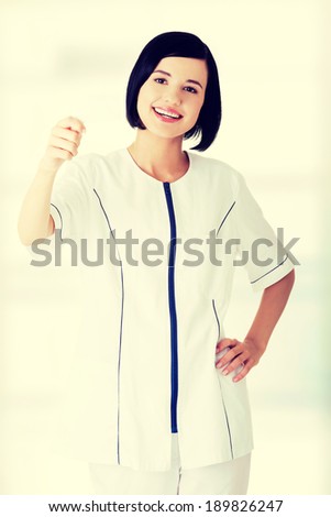 Woman doctor or nurse holding blank business card in her hand 