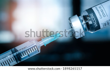 syringe and a vaccine covid19 bottle. SARS - CoV2 Vaccine concept. A medical needle entering into a glass vial of COVID-19 Vaccine. Royalty-Free Stock Photo #1898265157