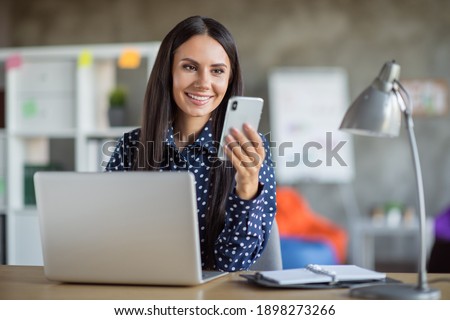 Photo of young lovely pretty attractive cheerful smiling businesswoman using phone work in laptop at office workplace