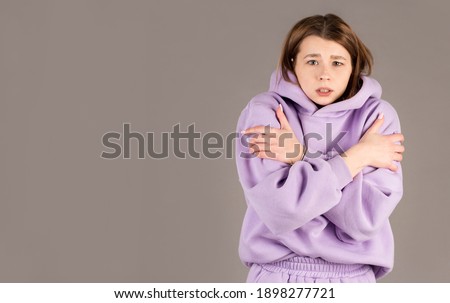 Half-length portrait of freezing woman , isolated on gray