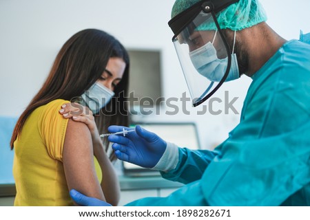 Male doctor or nurse vaccine to a patient's shoulder - Vaccination and prevention against coronavirus pandemic Royalty-Free Stock Photo #1898282671