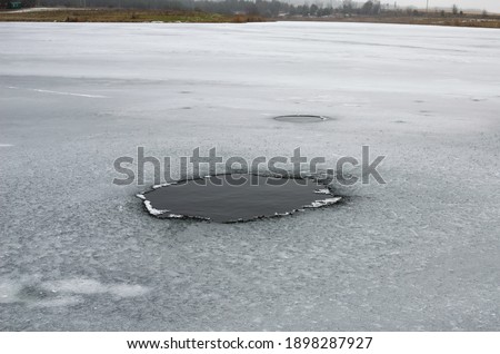 A hole in the ice. A dangerous place to walk on ice Royalty-Free Stock Photo #1898287927
