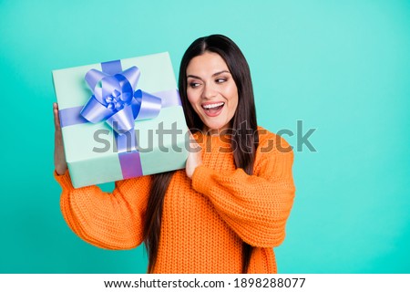 Photo of excited crazy lady hold gift box open mouth wear orange pullover isolated turquoise color background