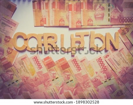 the letters of the alphabet are in the form of the word "corruption" with a background in Indonesian currency, Aceh Indonesia