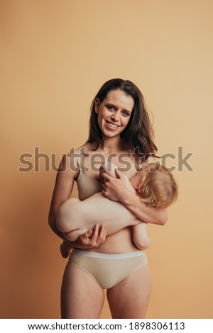 Breastfeeding baby. Young mother holding and nursing her newborn child.
