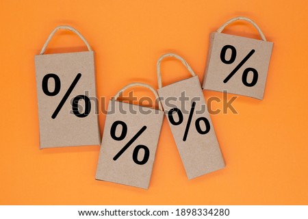 Percentage sign on the craft package on a orange background. creative idea for online shopping, sale, supermarket, discount promotion and black friday concept. Copy space for text