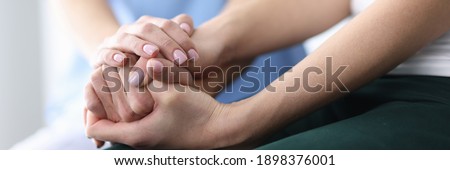 Patient's and doctor's hands are folded together. Medical care and support concept Royalty-Free Stock Photo #1898376001