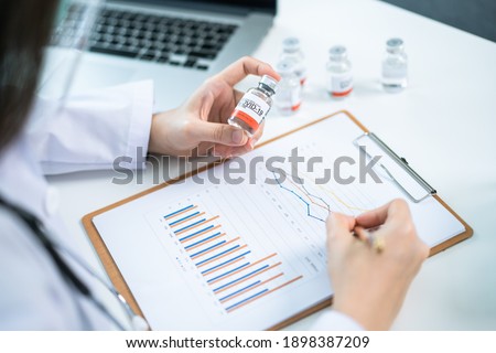 Asian female doctor reporting a diagnostic result of Coronavirus or COVID-19 vaccine usage in patient, 2019-nCoV COVID19 cases statistic. Woman analyst - researcher making a video conference. Royalty-Free Stock Photo #1898387209