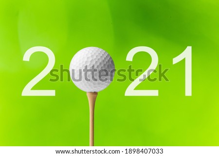 A golf ball for Happy New Year 2021 on the green background.