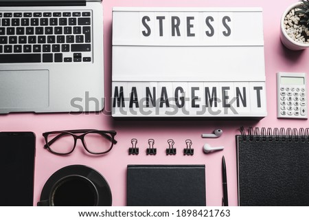 Flat lay composition of lightbox with phrase Stress Management on pink background