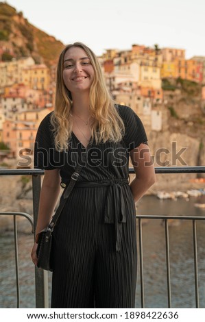 Young beautiful woman in black dress in front of Manarola (Cinque Terre)