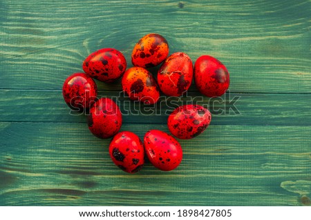 Macro photo of red easter quail egg. Painted red quail eggs on a green wood background. Easter