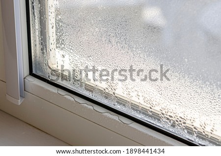 Drops of condensate and black mold on a substandard metal-plastic window. Plastic. Ecology Royalty-Free Stock Photo #1898441434