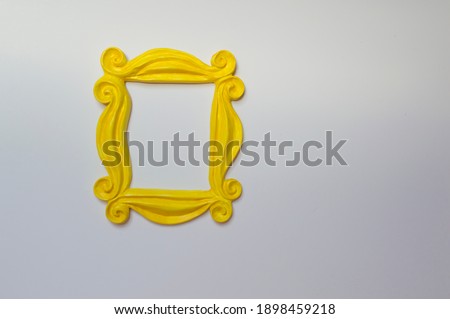 Yellow photo frame or mirror frame with a white background, to frame texts or images. Royalty-Free Stock Photo #1898459218